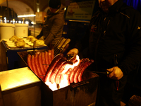 A person prepares sausages traditionally served at blue Nyska van in Krakow, Poland on December 18, 2024. (