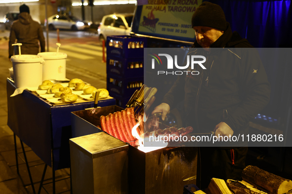 A person prepares sausages traditionally served at blue Nyska van in Krakow, Poland on December 18, 2024. 