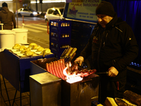 A person prepares sausages traditionally served at blue Nyska van in Krakow, Poland on December 18, 2024. (