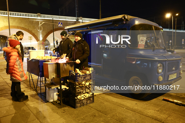 A person prepares sausages traditionally served at blue Nyska van in Krakow, Poland on December 18, 2024. 