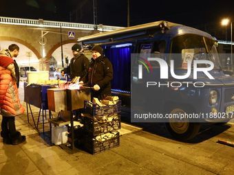 A person prepares sausages traditionally served at blue Nyska van in Krakow, Poland on December 18, 2024. (