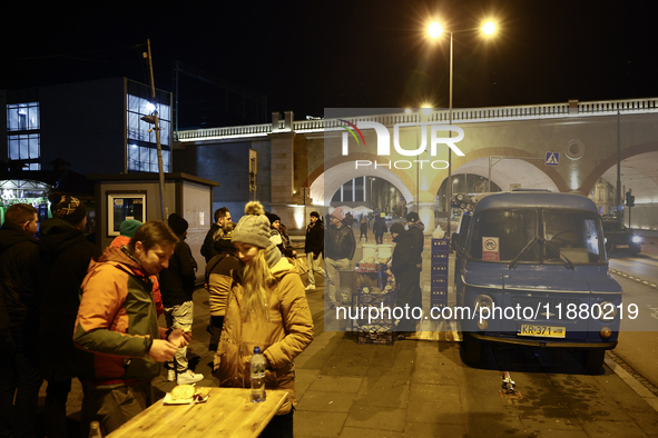 A person prepares sausages traditionally served at blue Nyska van in Krakow, Poland on December 18, 2024. 