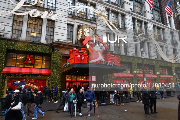 People stand outside Macy's Department Store windows in New York, N.Y., on December 17, 2024. 