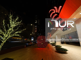 Giant candy canes hang outside an office building on W. 57th Street in New York, N.Y., on December 12, 2024. (