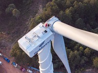 Workers lift the blades of a wind turbine at the construction site of the Guishushan Wind Farm project in Qingyun town of Congjiang county,...