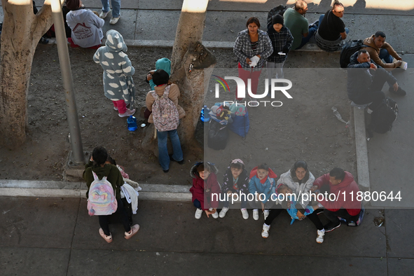 Migrants wait for their CBP One asylum appointments and observe from the Chaparral PedWest border as Mexican migrants who have been deported...