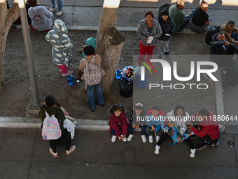 Migrants wait for their CBP One asylum appointments and observe from the Chaparral PedWest border as Mexican migrants who have been deported...