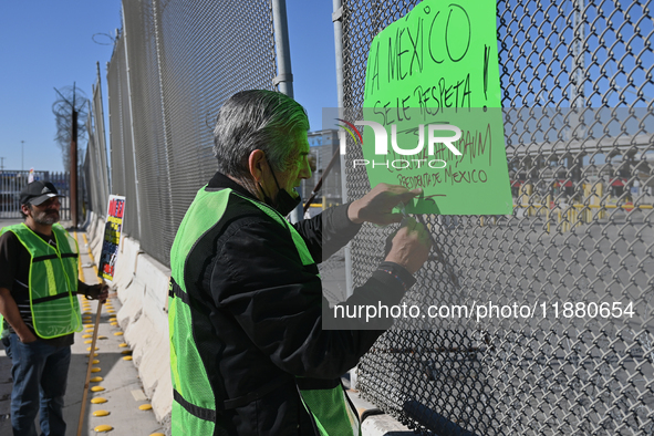 Angels Without Borders activist Sergio Tamai posts posters on a port of entry fence demanding respect for Mexico and its people during a dem...