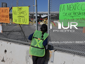 A migrant seeking asylum looks into the United States as migrants like her and activists demonstrate for migrants' rights, the arrival of Pr...