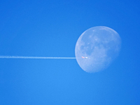 A passenger plane flies past the moon in Yantai, China, on December 19, 2024. (