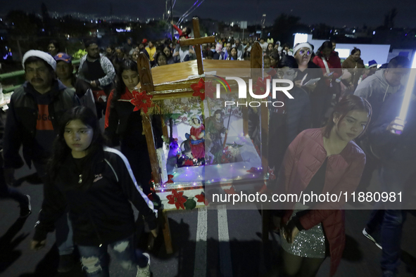 Residents of the town of Culhuacan in Mexico City, on December 18, 2024,  walk on a vehicular bridge while participating in a posada on Chri...