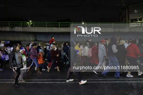 Residents of the town of Culhuacan in Mexico City, on December 18, 2024,  walk on a vehicular bridge while participating in a posada on Chri...