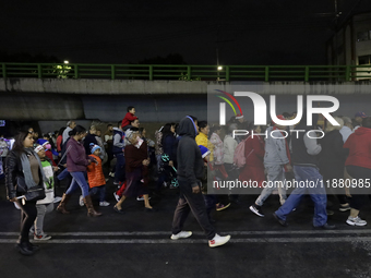 Residents of the town of Culhuacan in Mexico City, on December 18, 2024,  walk on a vehicular bridge while participating in a posada on Chri...