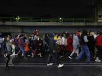 Residents of the town of Culhuacan in Mexico City, on December 18, 2024,  walk on a vehicular bridge while participating in a posada on Chri...