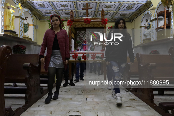 Residents of the town of Culhuacan in Mexico City, on December 18, 2024,  walk on a vehicular bridge while participating in a posada on Chri...