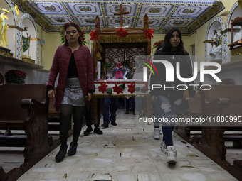 Residents of the town of Culhuacan in Mexico City, on December 18, 2024,  walk on a vehicular bridge while participating in a posada on Chri...