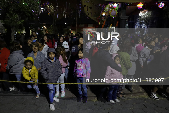 Residents of the town of Culhuacan in Mexico City, on December 18, 2024,  walk on a vehicular bridge while participating in a posada on Chri...