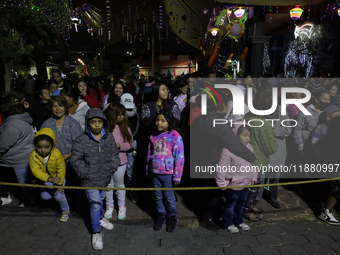 Residents of the town of Culhuacan in Mexico City, on December 18, 2024,  walk on a vehicular bridge while participating in a posada on Chri...