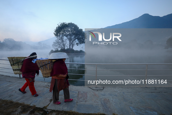 A Nepali woman walks along the edge of the Taudaha wetland on the outskirts of Kathmandu, Nepal, on December 19, 2024. 