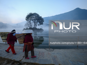 A Nepali woman walks along the edge of the Taudaha wetland on the outskirts of Kathmandu, Nepal, on December 19, 2024. (