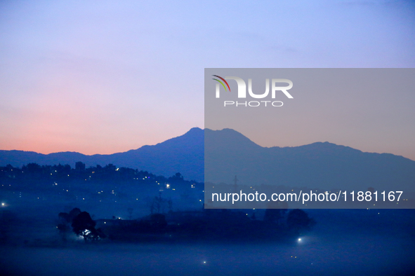 The sun rises behind the hills surrounding Kathmandu Valley as the cold fog covers the bowl-shaped valley in Kathmandu, Nepal, on December 1...