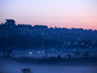 The sun rises behind the hills surrounding Kathmandu Valley as the cold fog covers the bowl-shaped valley in Kathmandu, Nepal, on December 1...