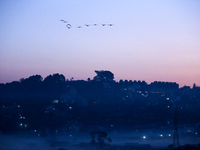 The sun rises behind the hills surrounding Kathmandu Valley as the cold fog covers the bowl-shaped valley in Kathmandu, Nepal, on December 1...