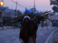 A Nepali woman carries sticks to make a bonfire as the temperature drops in Kathmandu, Nepal, on December 19, 2024, with the onset of winter...