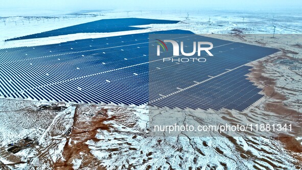 An aerial view shows a solar array and wind turbine cluster at Beitan New Energy Industrial Park deep in the desert in Zhangye, China, on De...