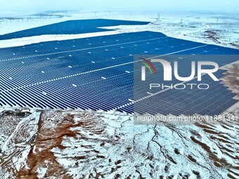 An aerial view shows a solar array and wind turbine cluster at Beitan New Energy Industrial Park deep in the desert in Zhangye, China, on De...