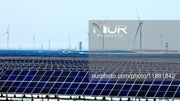 An aerial view shows a solar array and wind turbine cluster at Beitan New Energy Industrial Park deep in the desert in Zhangye, China, on De...