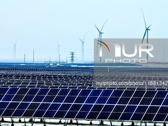 An aerial view shows a solar array and wind turbine cluster at Beitan New Energy Industrial Park deep in the desert in Zhangye, China, on De...