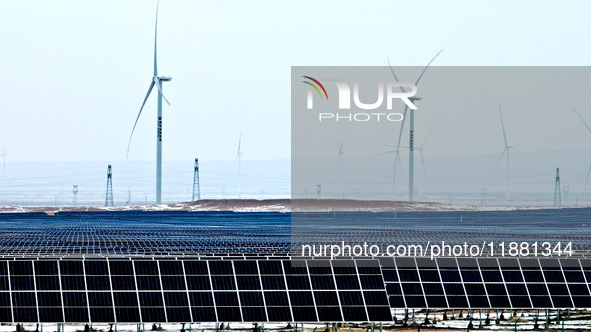 An aerial view shows a solar array and wind turbine cluster at Beitan New Energy Industrial Park deep in the desert in Zhangye, China, on De...