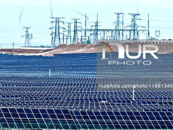 An aerial view shows a solar array and wind turbine cluster at Beitan New Energy Industrial Park deep in the desert in Zhangye, China, on De...