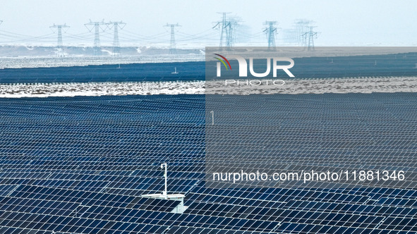 An aerial view shows a solar array and wind turbine cluster at Beitan New Energy Industrial Park deep in the desert in Zhangye, China, on De...