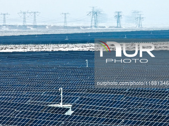 An aerial view shows a solar array and wind turbine cluster at Beitan New Energy Industrial Park deep in the desert in Zhangye, China, on De...