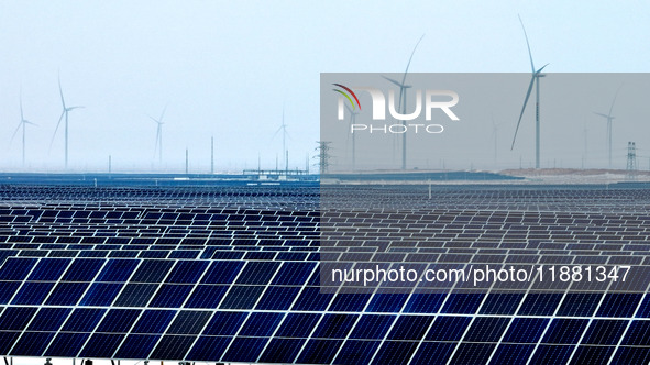 An aerial view shows a solar array and wind turbine cluster at Beitan New Energy Industrial Park deep in the desert in Zhangye, China, on De...