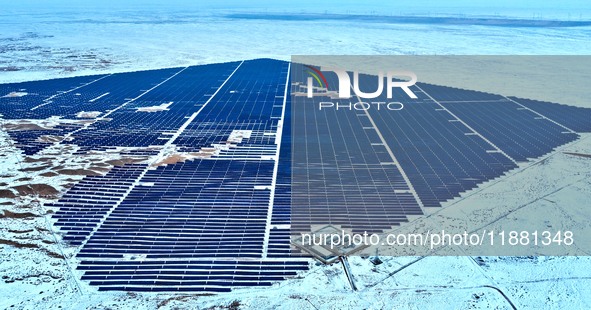 An aerial view shows a solar array and wind turbine cluster at Beitan New Energy Industrial Park deep in the desert in Zhangye, China, on De...