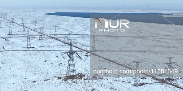 An aerial view shows a solar array and wind turbine cluster at Beitan New Energy Industrial Park deep in the desert in Zhangye, China, on De...