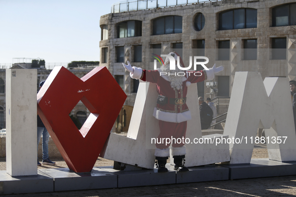 In Jerusalem, Israel, on December 19, 2024, Christian Palestinian Issa Kassissieh, dressed as Santa Claus, greets the public from the old ci...