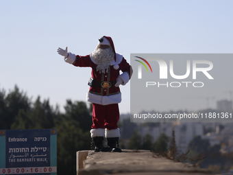 In Jerusalem, Israel, on December 19, 2024, Christian Palestinian Issa Kassissieh, dressed as Santa Claus, greets the public from the old ci...