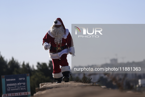 In Jerusalem, Israel, on December 19, 2024, Christian Palestinian Issa Kassissieh, dressed as Santa Claus, greets the public from the old ci...