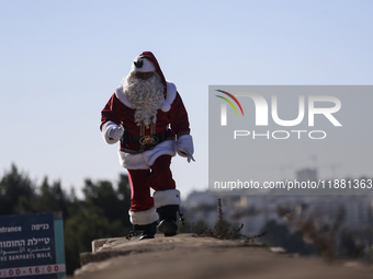 In Jerusalem, Israel, on December 19, 2024, Christian Palestinian Issa Kassissieh, dressed as Santa Claus, greets the public from the old ci...