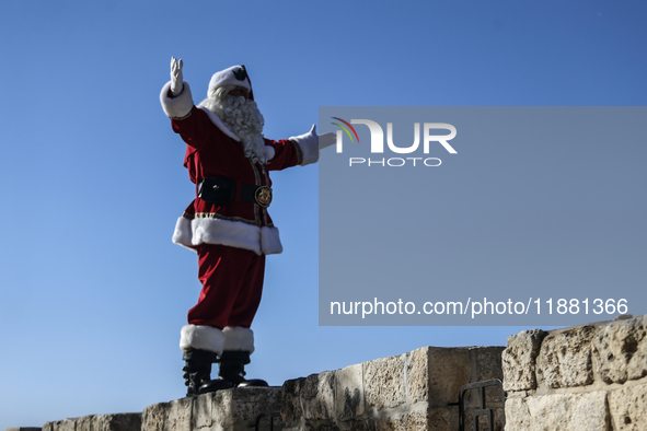 In Jerusalem, Israel, on December 19, 2024, Christian Palestinian Issa Kassissieh, dressed as Santa Claus, greets the public from the old ci...