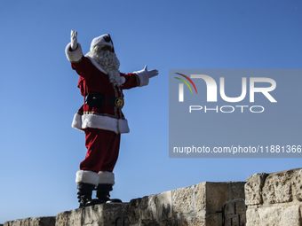 In Jerusalem, Israel, on December 19, 2024, Christian Palestinian Issa Kassissieh, dressed as Santa Claus, greets the public from the old ci...