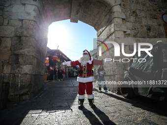 In Jerusalem, Israel, on December 19, 2024, Christian Palestinian Issa Kassissieh, dressed as Santa Claus, greets the public from the old ci...