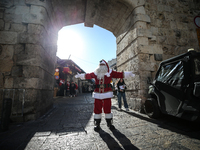 In Jerusalem, Israel, on December 19, 2024, Christian Palestinian Issa Kassissieh, dressed as Santa Claus, greets the public from the old ci...