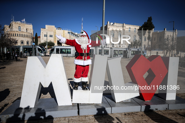 In Jerusalem, Israel, on December 19, 2024, Christian Palestinian Issa Kassissieh, dressed as Santa Claus, greets the public from the old ci...