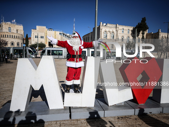 In Jerusalem, Israel, on December 19, 2024, Christian Palestinian Issa Kassissieh, dressed as Santa Claus, greets the public from the old ci...