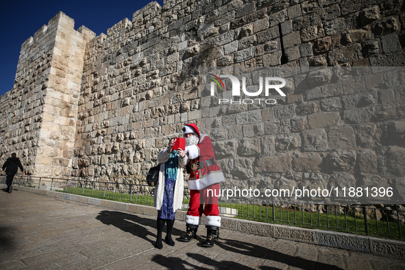 In Jerusalem, Israel, on December 19, 2024, Christian Palestinian Issa Kassissieh, dressed as Santa Claus, greets the public from the old ci...